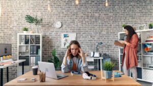 woman stressed sitting at desk in need of sensory audit