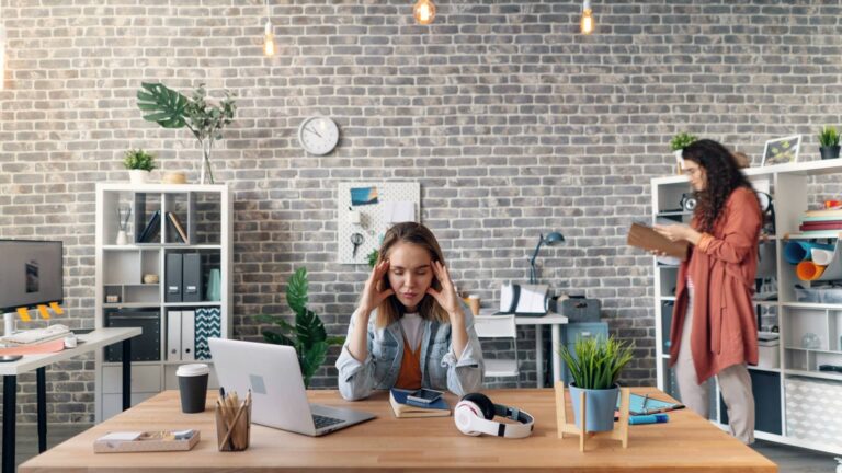 woman stressed sitting at desk in need of sensory audit