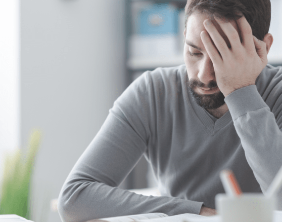 Exhausted Man with head in palm