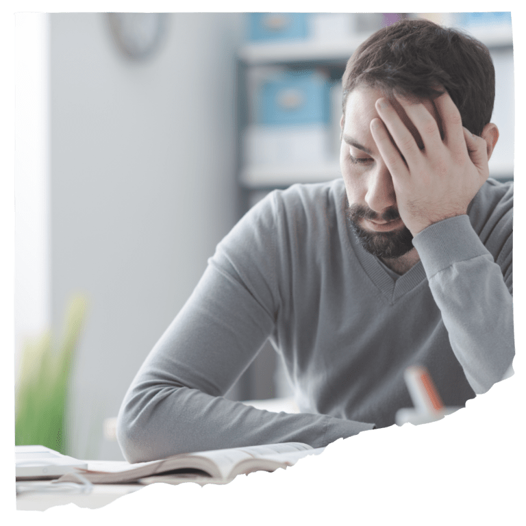 Exhausted man with head in palm