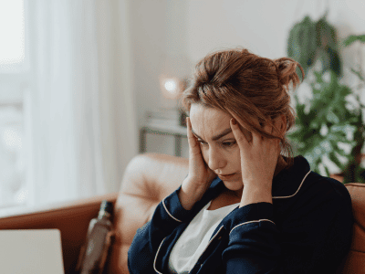 Anxious and Overwhelmed Woman Holding Head Looking Distressed